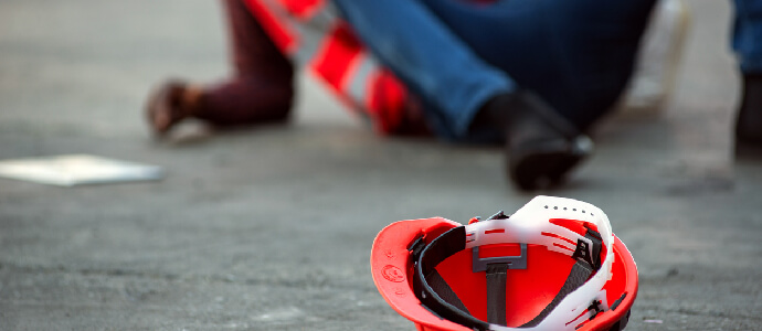 construction officer laying on ground with hat to the side