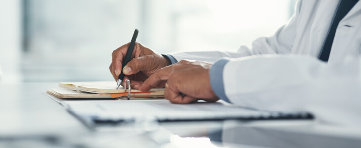 doctor at a desk filling out forms