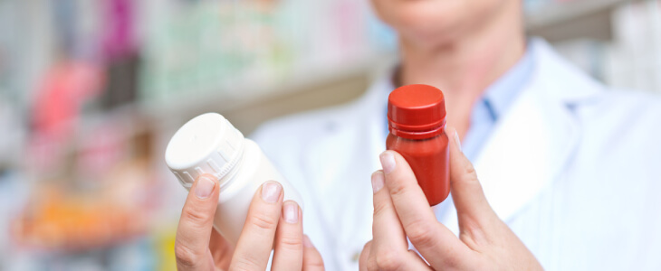 woman holding up two different prescription bottles