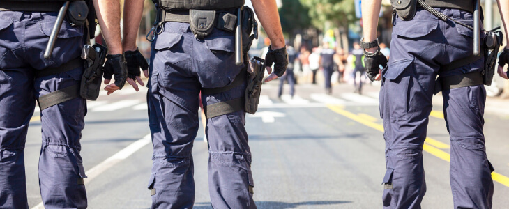 3 police officers standing on a street