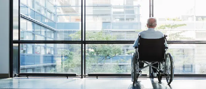 elderly man in wheelchair staring out the window